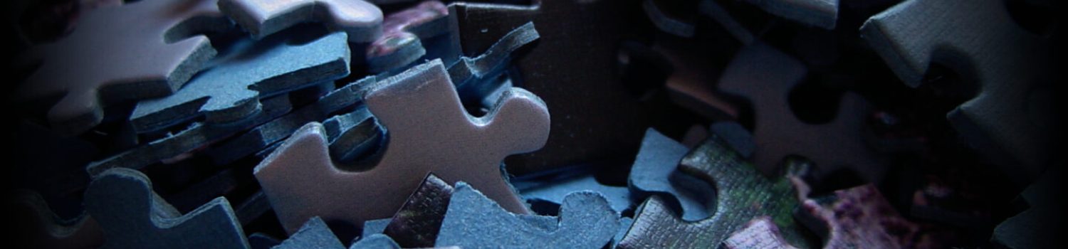 Layered cardboard puzzle pieces in low light