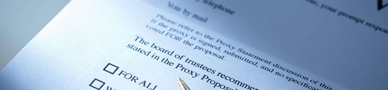 The proxy vote business letter with a pen resting on the document ready to authorize the governing members. Proxy vote by mail, a common business document sent to all participating business interested party and stakeholders. Photographed in horizontal format in dramatic lighting spotlighting the checkboxes.