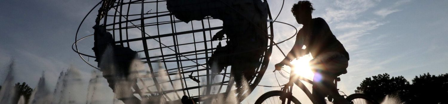 Cyclist silhouette in front of globe fountain